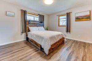 Un dormitorio con una cama y dos ventanas. en Newly Remodeled Home in Storm Lake with Private Yard, en Storm Lake