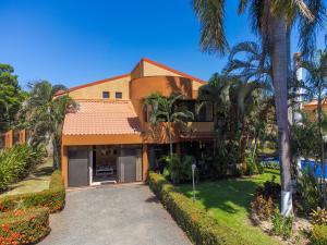 Una casa con palmeras y una entrada para coches. en Green Villas El Coco, en Coco