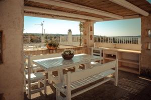 een patio met een tafel en banken op een balkon bij Trulli Dimora Florenzo in Selva di Fasano