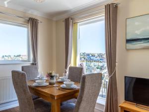 ブリクサムにある2 bed in Brixham 78185のテーブルと椅子とテレビのあるダイニングルーム