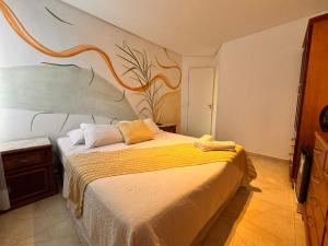 1 dormitorio con 1 cama con una pintura en la pared en O melhor na Praia do Futuro, en Fortaleza