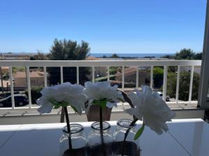 two vases with white flowers sitting on a table at T2 soleil et mer in Bandol