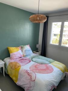 a bedroom with a large bed with colorful sheets at T2 soleil et mer in Bandol