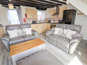 a living room with two couches and a kitchen at Hillview in Colwyn Bay