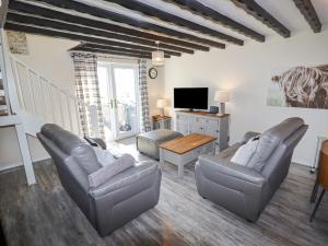 a living room with two couches and a tv at Hillview in Colwyn Bay