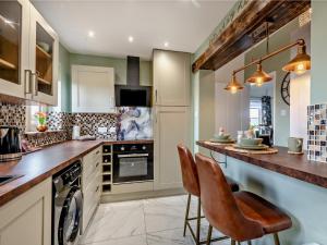 - une cuisine avec un comptoir et 2 chaises dans l'établissement 1 Bed in Beccles 94297, à Geldeston