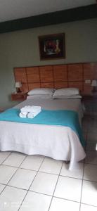 a bedroom with a bed with two towels on it at Hotel Don Enrique in El Soberbio