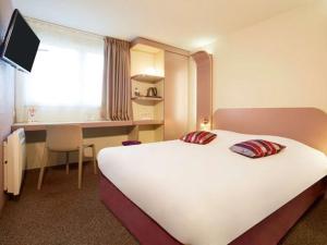 a hotel room with a large bed and a desk at Kyriad Deauville - St Arnoult in Deauville