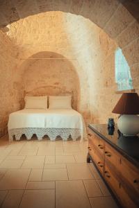 een slaapkamer met een bed in een bakstenen muur bij Trulli Dimora Florenzo in Selva di Fasano