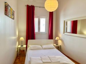 1 dormitorio con cama blanca y cortinas rojas en With Terrasse - 3 Bedroom, 3 Bathroom Triplex, en Lisboa