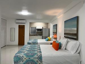 um quarto com 2 camas e uma cozinha em Posada Centric Studio Isla Verde em San Juan