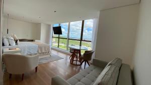 ein Wohnzimmer mit einem Sofa, einem Bett und einem Fenster in der Unterkunft WA Hotel Caruaru in Caruaru