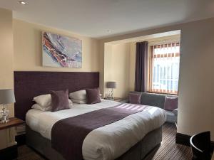 um quarto de hotel com uma cama grande e uma janela em The Bell Guesthouse em Peterlee