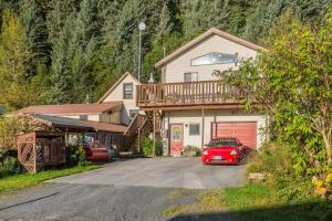 a house with a car parked in a driveway at Alaska's Point of View Full Suite in Seward