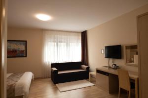 um quarto de hotel com uma cama e uma cadeira e uma televisão em Scallop Rooms self check-in em Zadar