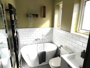 ein Badezimmer mit einer Badewanne, einem WC und einem Waschbecken in der Unterkunft Spacious 3 bed APT sleeps 5 near Bournemouth Beach in Bournemouth