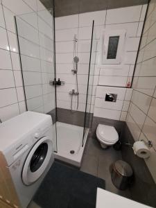 a bathroom with a shower and a washing machine at Guest house del Mar in Iraklitsa