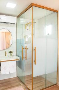 a glass shower in a bathroom with a sink at Villa Beija-Flor 1 - Suíte alexa com piscina privativa in Japaratinga
