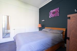 a bedroom with a bed and a purple wall at The Eden Apartment, Edinburgh City Center in Edinburgh