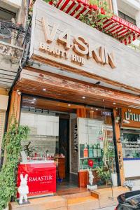 un magasin devant un institut de beauté muni d'un panneau. dans l'établissement New York Loft & Japanese Magic by V4SKIN, à Bangkok