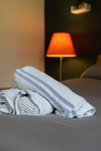 een stapel handdoeken zittend op een bed met een lamp bij The Eden Apartment, Edinburgh City Center in Edinburgh
