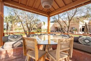 an outdoor patio with a table and chairs at Villa May sur le Golf de la Palmeraie with Cooker and Butler included in Marrakech