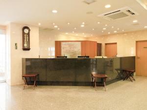 una sala d'attesa con bancone e sedie in un edificio di Centurion Hotel Hamamatsu a Hamamatsu