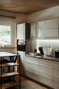 a kitchen with white cabinets and a table and a window at Ferienwohnung „Göttschied“ in Idar-Oberstein