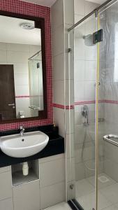 La salle de bains est pourvue d'un lavabo et d'une douche avec un miroir. dans l'établissement Love Birds Palace, à Mombasa