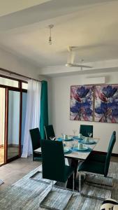 une salle à manger avec une table et des chaises vertes dans l'établissement Love Birds Palace, à Mombasa