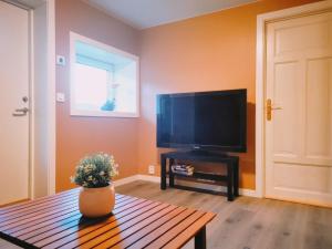 een woonkamer met een flatscreen-tv en een tafel bij Mossemarka Guesthouse in Moss