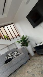 Il comprend un salon doté d'un canapé et d'une télévision à écran plat. dans l'établissement Love Birds Palace, à Mombasa