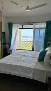 - une chambre avec un grand lit et une grande fenêtre dans l'établissement Love Birds Palace, à Mombasa