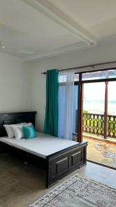 Ce lit se trouve dans un dortoir doté d'une grande fenêtre. dans l'établissement Love Birds Palace, à Mombasa