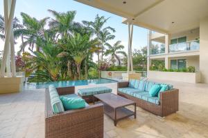 um pátio exterior com uma piscina, mobiliário e palmeiras em Hemingway Poolside em Deerfield Beach