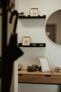 a shelf with two pictures and a mirror on a wall at Ferienwohnung „Göttschied“ in Idar-Oberstein