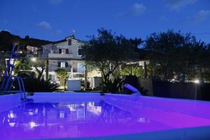 a swimming pool at night with a house in the background at Villa Carol in Santa Maria di Castellabate