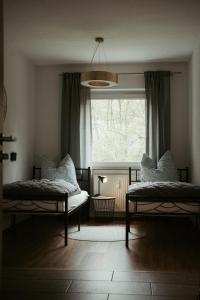 a bedroom with two beds in front of a window at Ferienwohnung „Göttschied“ in Idar-Oberstein