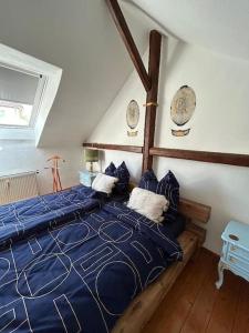 ein Schlafzimmer mit einem blauen Bett mit blauen Kissen in der Unterkunft Gemütliches Scheunenfachwerkhaus in Bad Soden am Taunus