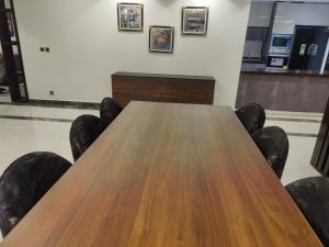 einen Konferenzraum mit einem Holztisch und Stühlen in der Unterkunft Gold Crest Apartments - DHA P4 in Lahore