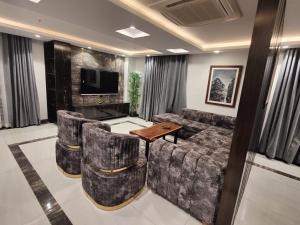 ein Wohnzimmer mit einem Sofa und einem Tisch in der Unterkunft Gold Crest Apartments - DHA P4 in Lahore