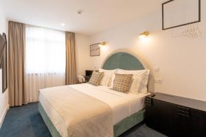 Una habitación de hotel con una cama grande y una ventana. en Westlight Lisboa Madalena, en Lisboa 41 fotos más