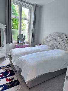 1 dormitorio con cama blanca y ventana en Unique apartment in stunning Manor house, en Potterne