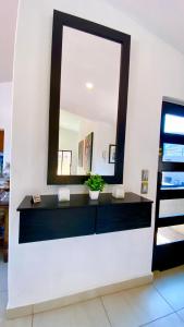 a mirror on a white wall with a sink at San Angel Villas in San Antonio