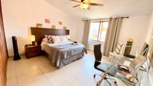 a bedroom with a bed and a desk and a window at San Angel Villas in San Antonio