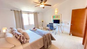 a bedroom with a bed with a ceiling fan and a desk at San Angel Villas in San Antonio