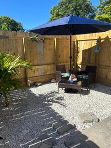 a patio with an umbrella and chairs and a bench at Villa Pulido-Cardona in Miami Gardens