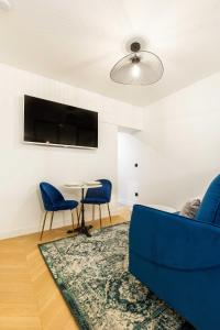 ein Wohnzimmer mit einem blauen Sofa und einem Tisch in der Unterkunft Chic Apartment in the Prestigious Saint Honoré in Paris