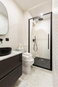 ein Bad mit einem WC und einer Glasdusche in der Unterkunft Chic Apartment in the Prestigious Saint Honoré in Paris