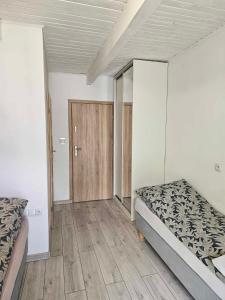 um quarto com 2 camas e piso em madeira em AGRO-Jabłońscy em Miałkówek
